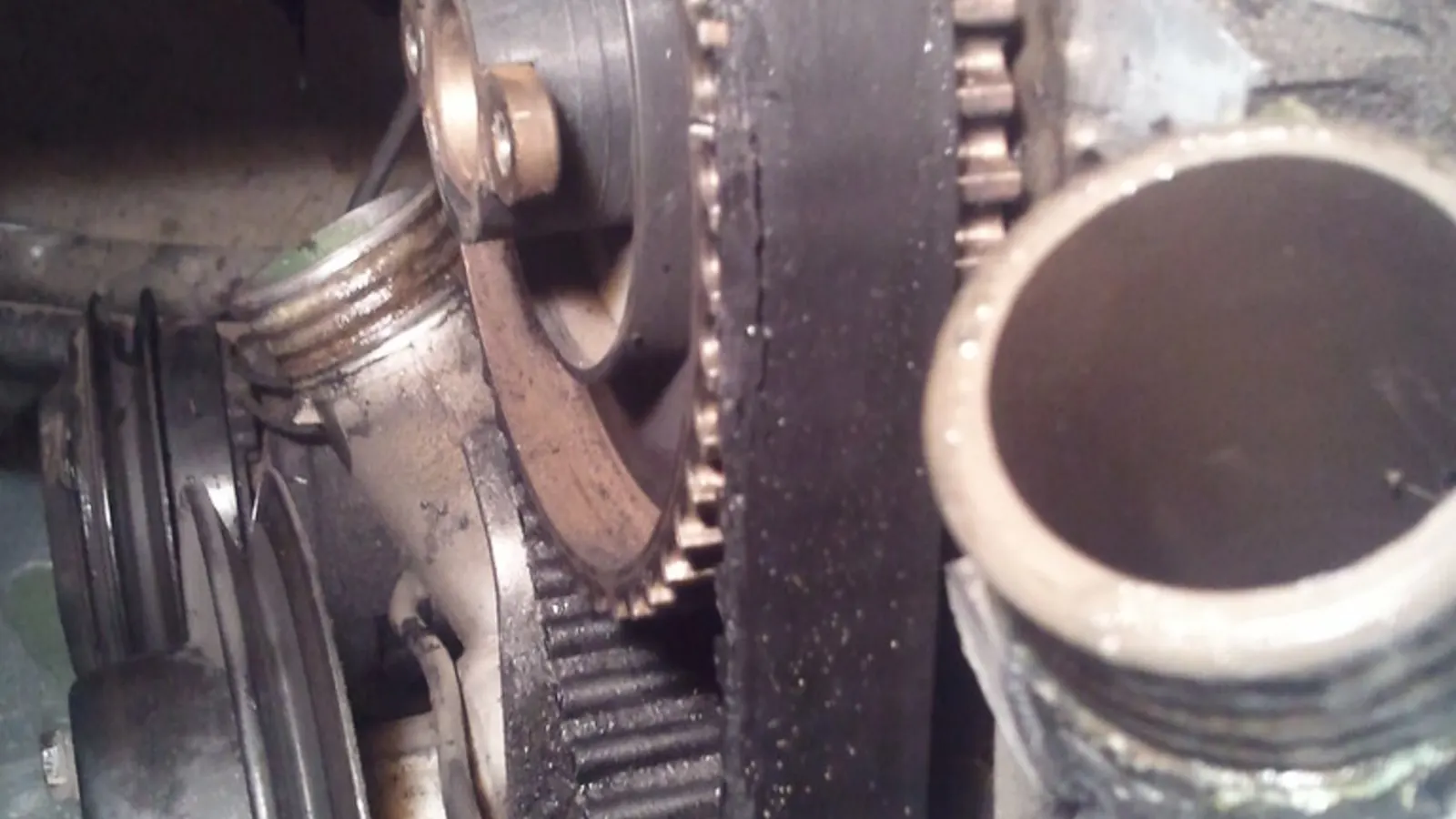 Penutup timing enjin terbuka menunjukkan timing chain logam dan tensioner